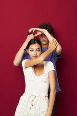 Fototapeta premium a guy stands behind a girl and holds her hair red background