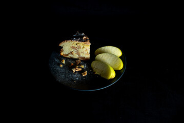 charlotte on a saucer with apples on a dark background © Екатерина Абрамова