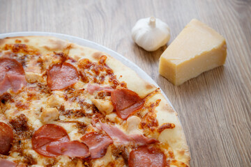 pizza with chicken breast, mozzarella, salami and white sauce