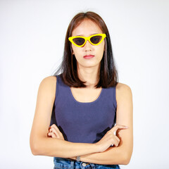 Portrait isolated closeup studio cutout shot of Asian female model in crop top shirt jeans and sunglasses smiling look at camera on white background