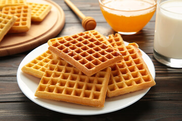 Belgian waffles on grey background. Belgian waffles with honey and milk. Freshly baked Belgian waffles.