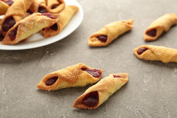 Tasty bagels with strawberry jam on grey concrete background. Homemade cookies
