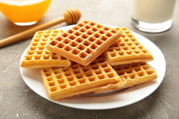 Belgian waffles on grey background. Belgian waffles with honey and milk. Freshly baked Belgian waffles.
