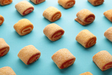 Homemade cookies, mini rolls with apricot jam on blue background. Top view