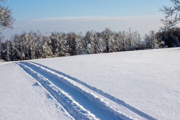 Fototapeta na wymiar the tracks of a snowmobile on the snow