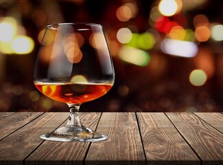 Glass of alcohol whiskey on the bar counter. Blurred interior of bar at the background.