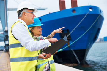 Looking out for the right ship. Two dock workers conferring among themselves while surveying the...