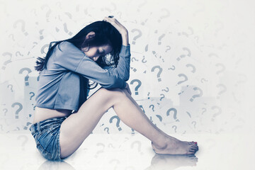 Depressed woman sitting with question marks