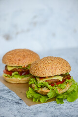 two big juicy fresh burgers on a light background vertical photo
