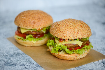 two big juicy fresh burgers on a light background
