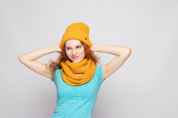 red-haired girl in a warm hat on a light background