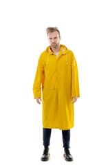 A middle-aged white man wearing a yellow raincoat standing over isolated white background looks happy. Worker concept.