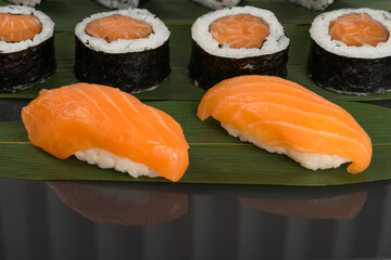 sushi and rolls with red salmon fillet on bamboo leaf, close-up