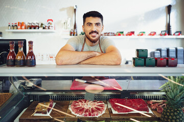 Portrait of confident young salesman standing in butcher's shop