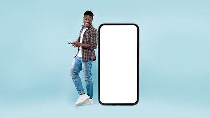 Black man leaning on white empty smartphone screen, using phone
