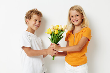 Fototapeta na wymiar Boy and girl with a bouquet of flowers gift birthday holiday childhood light background