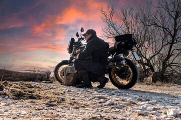 Plakat Sunset background with motorcycle and biker relaxing