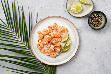 Grilled shrimps or tiger prawns served with lime, garlic and fresh herbs on scandi round plate on...