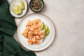 Grilled shrimps or tiger prawns served with lime, garlic and fresh herbs on scandi round plate on concrete surface. Pescatarian protein nutrition