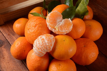 Fresh mandarin fruit  with leaves from the orchard. Home gardening. Organic mandarin whole and slices. Orange color.