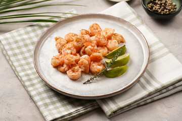 Grilled shrimps or tiger prawns served with lime, garlic and fresh herbs on scandi round plate on concrete surface. Pescatarian protein nutrition