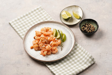 Grilled shrimps or tiger prawns served with lime, garlic and fresh herbs on scandi round plate on concrete surface. Pescatarian protein nutrition