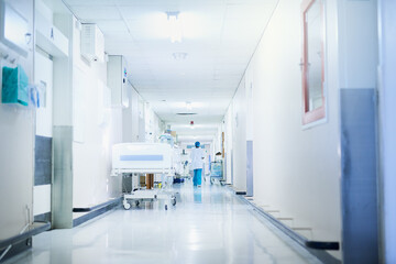 This way to wellness. Rearview shot of a surgeon walking down a hospital corridor.