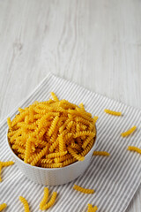 Raw Dry Organic Rotini Pasta Ready to Cook, side view. Copy space.