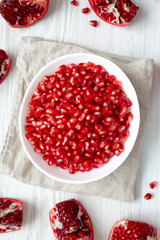 Red Pomegranate Seeds in a White Bowl , top view. Flat lay, overhead, from above.