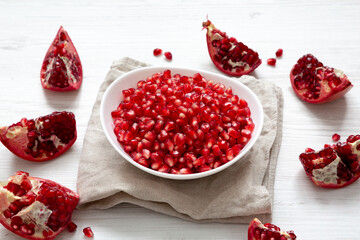 Red Pomegranate Seeds in a White Bowl , side view.