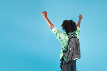 Successful student. African american guy shaking fists, raising arms, standing with backpack over...