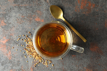 Concept of hot drink with buckwheat tea on dark textured table