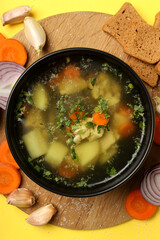 Concept of tasty food with chicken soup on yellow background