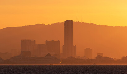 Scenery of a beautiful sunset with warm colors of the sun on a city skyline