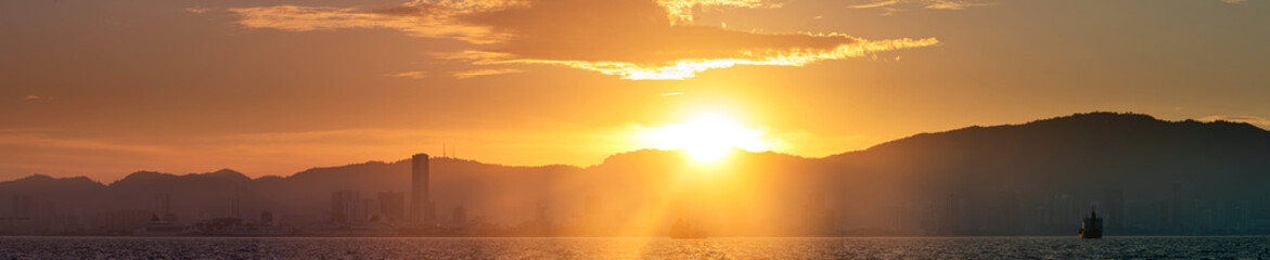 Scenery of a beautiful sunset with warm colors of the sun on a city skyline