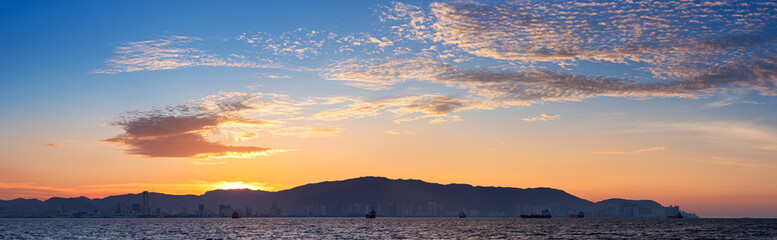 Scenery of a beautiful sunset with warm colors of the sun on a city skyline