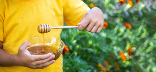 child eats honey in the garden. Nature