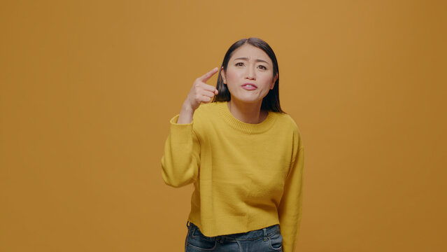 Angry woman showing index finger at camera and having argument, feeling furious and insulted in studio. Offended person arguing and having negative reaction, annoyed facial expression.