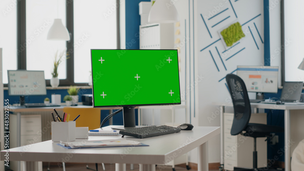 Poster empty office with green screen on computer display. nobody in space with isolated chroma key templat