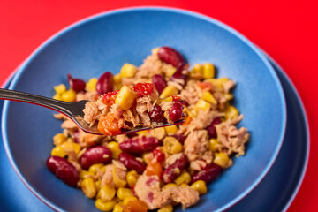 a plate of Mediterranean salad with tuna on a table.