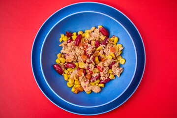 a plate of Mediterranean salad with tuna on a table.