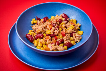 a plate of Mediterranean salad with tuna on a table.