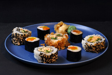 Japanese sushi on a porcelain plate on a black background