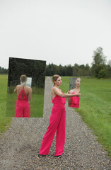 Schöne Frau mit Spiegel, Schöne Frau im rosaroten Hosenanzug mit Spiegel