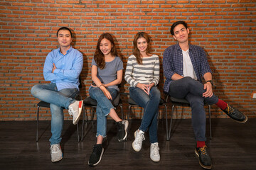 Potrait photo of Asian young startup business team in casual uniform in modern co-working space office. startup, casual work, lifestyle, brainstorming or young business concept