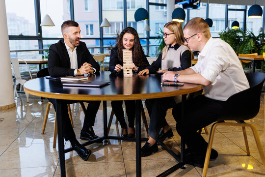 Businessmen are playing Jenga games. They sit in the office and play games. Concept photo for design and work.