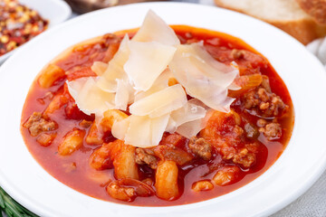 Minestrone soup with cavatappi pasta, beans and vegetables with crispy bread, horizontal, closeup