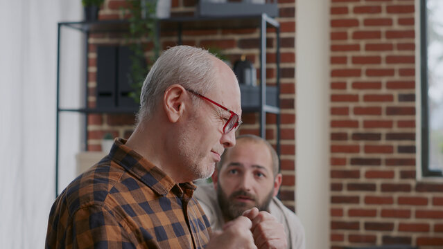 Close up of senior man complaining about addiction and mental health at aa therapy meeting. Old adult crying and talking about alcoholism to therapist at rehabilitation program session.