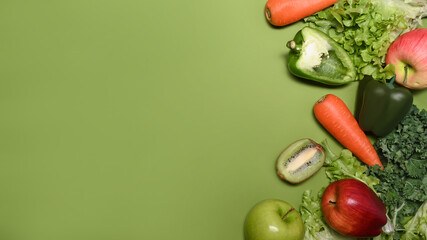 Colorful vegetables and fruits on green background with copy space. Healthy food concept.