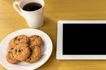 休憩時間にクッキーを食べ、タブレット端末を使うイメージ